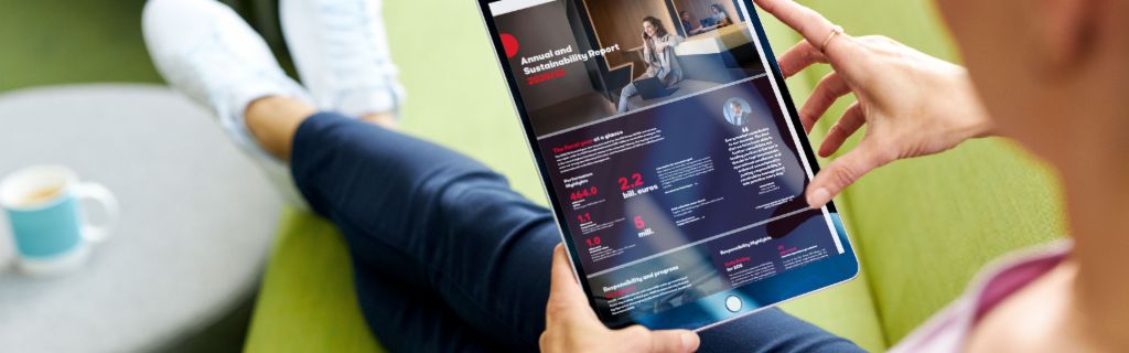 EOS ASR: Slika prikazuje mladu ženu koja drži tablet i na njemu gleda EOS-ov Godišnji izveštaj o održivosti.