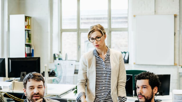 Two men and a woman having a debate in front of their computer screens.