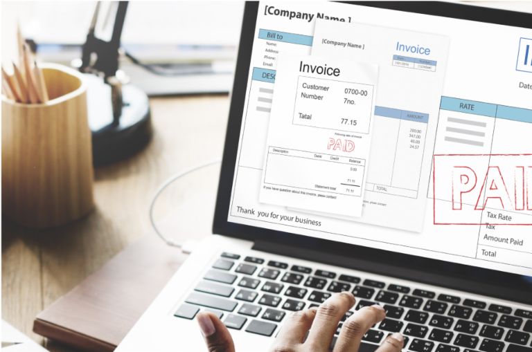 Invoicing: Co-workers in front of a laptop.