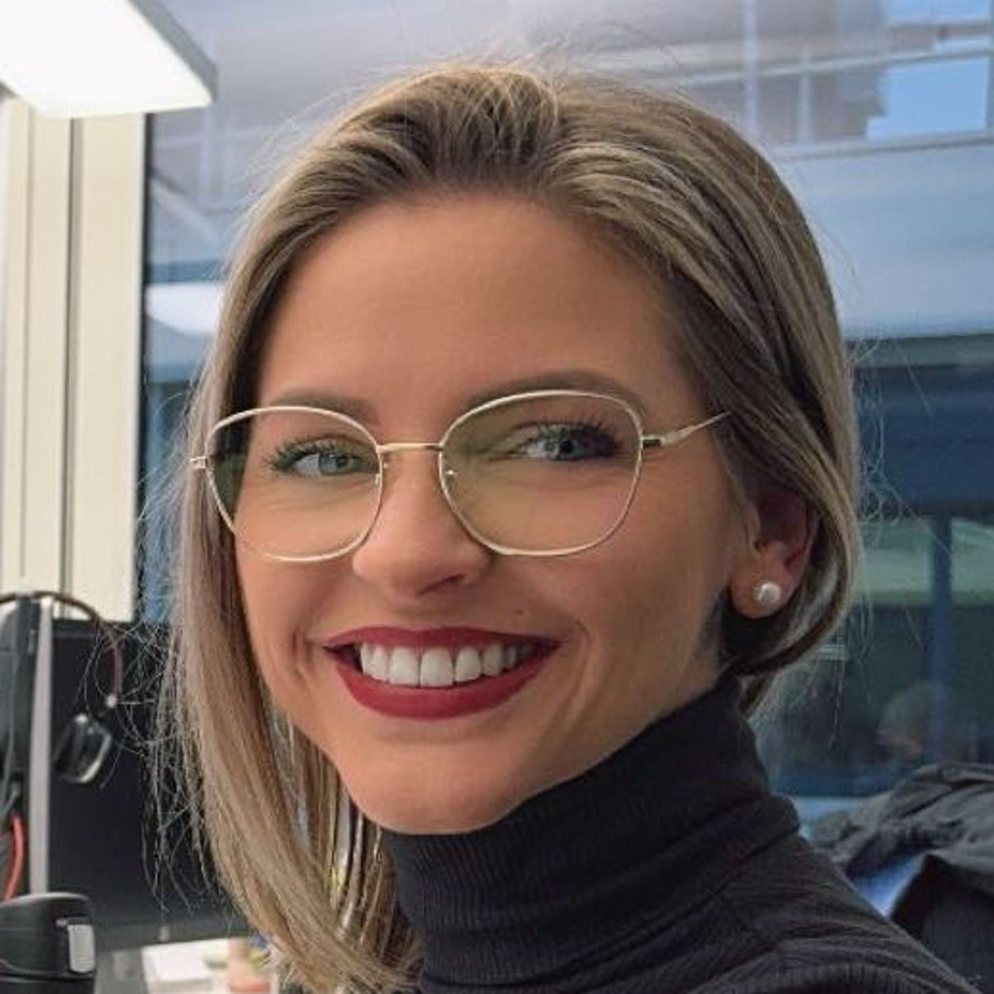 Genni Bollinger, specijalista za restrukturiranje duga u EOS-u u Švajcarskoj, sedi za svojim stolom u sivom džemperu sa dolčevicom i smeška se u kameru.