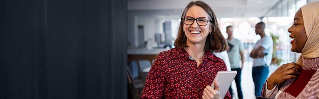 Dve srećne žene vode opušten kancelarijski razgovor